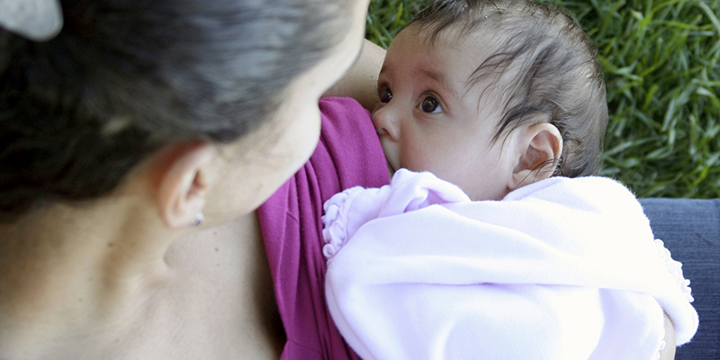 Breastfeeding baby looking at mother