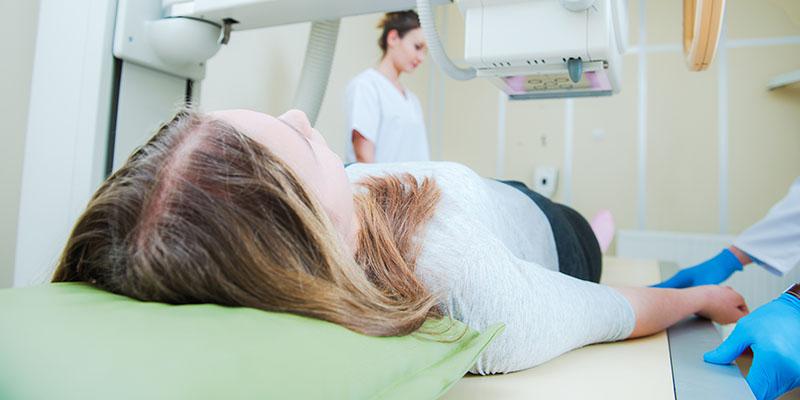 Image of a girl and hospital technicians preparing for a medical scan